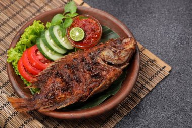 Ikan Bakar, taze salatalık ve domatesle servis edilen Endonezya usulü ızgara tilapia balığı.