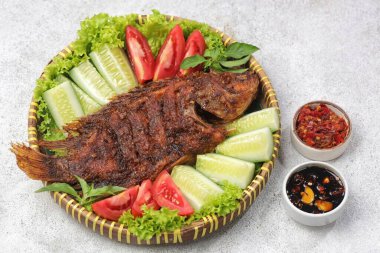 Ikan Bakar, taze salatalık ve domatesle servis edilen Endonezya usulü ızgara tilapia balığı.