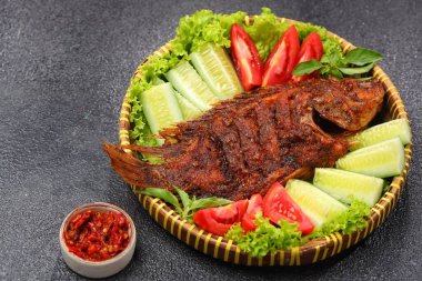 Ikan Bakar, taze salatalık ve domatesle servis edilen Endonezya usulü ızgara tilapia balığı.