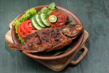 Ikan Bakar, taze salatalık ve domatesle servis edilen Endonezya usulü ızgara tilapia balığı.