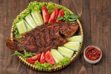 Ikan Bakar, taze salatalık ve domatesle servis edilen Endonezya usulü ızgara tilapia balığı.