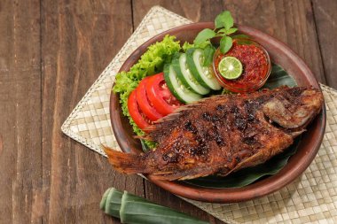 Ikan Bakar, taze salatalık ve domatesle servis edilen Endonezya usulü ızgara tilapia balığı.
