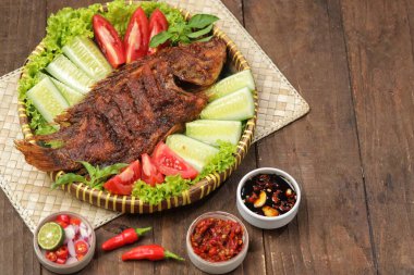 Ikan Bakar, taze salatalık ve domatesle servis edilen Endonezya usulü ızgara tilapia balığı.