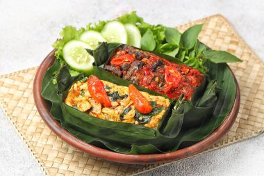 Geleneksel bir Endonezya yemeği olan Nasi Bakar, muz yapraklarına sarılmış tavuklu baharatlı pirinç..