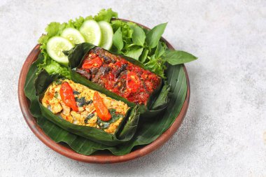 Geleneksel bir Endonezya yemeği olan Nasi Bakar, muz yapraklarına sarılmış tavuklu baharatlı pirinç..