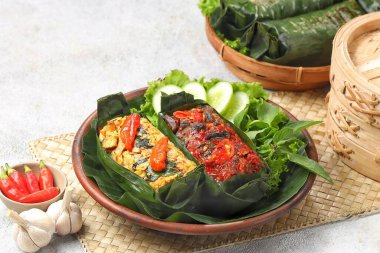 Geleneksel bir Endonezya yemeği olan Nasi Bakar, muz yapraklarına sarılmış tavuklu baharatlı pirinç..