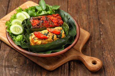 Geleneksel bir Endonezya yemeği olan Nasi Bakar, muz yapraklarına sarılmış tavuklu baharatlı pirinç..