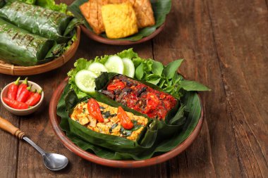 Geleneksel bir Endonezya yemeği olan Nasi Bakar, muz yapraklarına sarılmış tavuklu baharatlı pirinç..