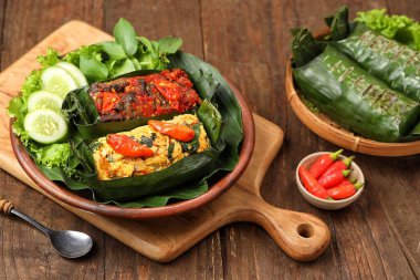 Geleneksel bir Endonezya yemeği olan Nasi Bakar, muz yapraklarına sarılmış tavuklu baharatlı pirinç..