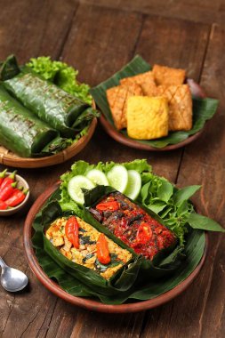 Geleneksel bir Endonezya yemeği olan Nasi Bakar, muz yapraklarına sarılmış tavuklu baharatlı pirinç..