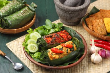 Geleneksel bir Endonezya yemeği olan Nasi Bakar, muz yapraklarına sarılmış tavuklu baharatlı pirinç..