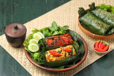 Geleneksel bir Endonezya yemeği olan Nasi Bakar, muz yapraklarına sarılmış tavuklu baharatlı pirinç..