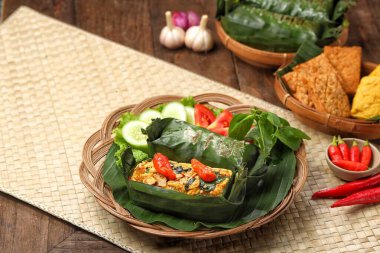 Geleneksel bir Endonezya yemeği olan Nasi Bakar, muz yapraklarına sarılmış tavuklu baharatlı pirinç..