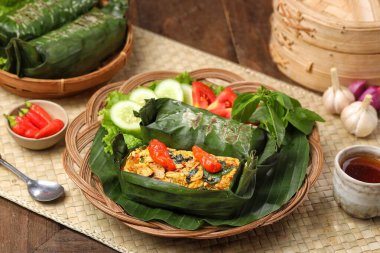 Geleneksel bir Endonezya yemeği olan Nasi Bakar, muz yapraklarına sarılmış tavuklu baharatlı pirinç..