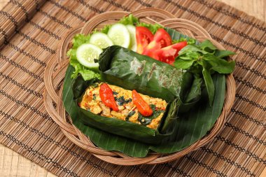 Geleneksel bir Endonezya yemeği olan Nasi Bakar, muz yapraklarına sarılmış tavuklu baharatlı pirinç..