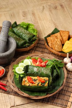 Geleneksel bir Endonezya yemeği olan Nasi Bakar, muz yapraklarına sarılmış tavuklu baharatlı pirinç..