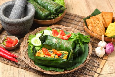 Geleneksel bir Endonezya yemeği olan Nasi Bakar, muz yapraklarına sarılmış tavuklu baharatlı pirinç..