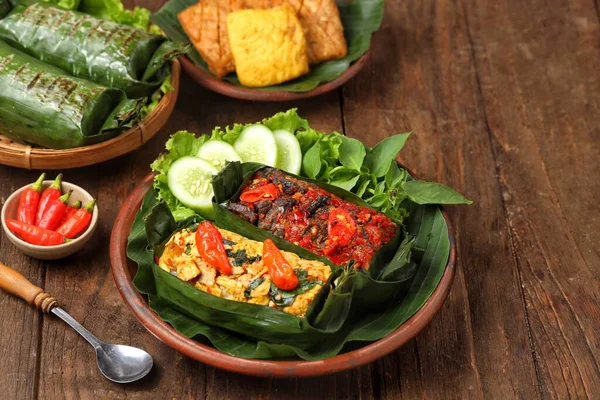 Geleneksel bir Endonezya yemeği olan Nasi Bakar, muz yapraklarına sarılmış tavuklu baharatlı pirinç..