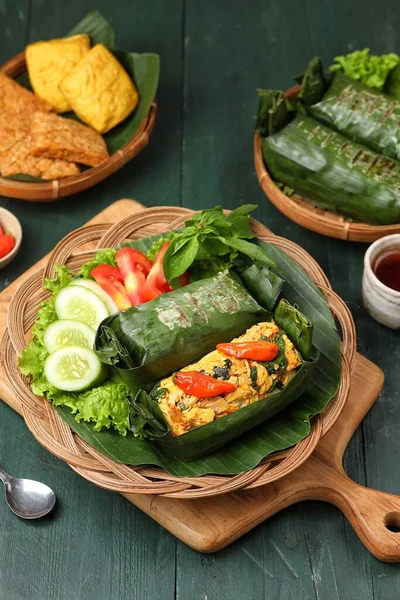 Geleneksel bir Endonezya yemeği olan Nasi Bakar, muz yapraklarına sarılmış tavuklu baharatlı pirinç..