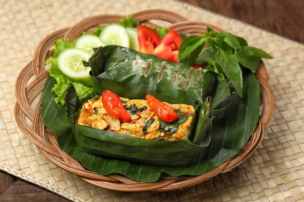 Geleneksel bir Endonezya yemeği olan Nasi Bakar, muz yapraklarına sarılmış tavuklu baharatlı pirinç..