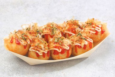 Takoyaki, buğday unundan yapılmış ve içi ahtapot parçalarıyla dolu küçük toplar şeklinde tipik bir Japon aperatifi..