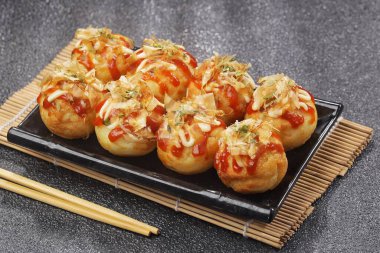 Takoyaki, buğday unundan yapılmış ve içi ahtapot parçalarıyla dolu küçük toplar şeklinde tipik bir Japon aperatifi..