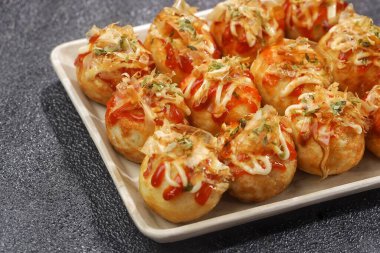 Takoyaki, buğday unundan yapılmış ve içi ahtapot parçalarıyla dolu küçük toplar şeklinde tipik bir Japon aperatifi..