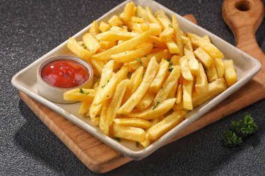 Ketçaplı patates kızartması ve ahşap arka planda ketçap.