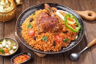 Tavuklu kızarmış pilav ve ahşap arka planda sebze.