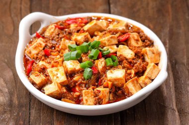 Tahta masadaki kasede baharatlı soya peyniri.