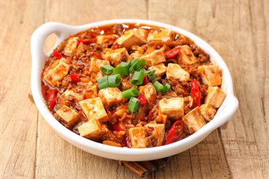 Kızarmış Çin eriştesi ve soya peyniri siyah arka planlı bir masada.