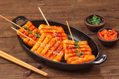 Tteokbokki, çiğnenmiş pirinç kekleri ve balık keklerinden yapılan popüler bir Kore sokak yemeği.