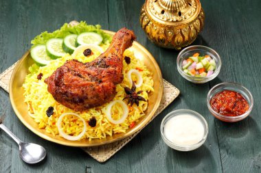 Kokulu Nasi Biryani geleneksel bir tabakta servis edilirken, aromatik baharatlar, taze tavuk, karamelize soğan ve taze otlarla pişirilmiş uzun taneli basmati pilavı servis edildi. Lezzetli Güney Asya ve Orta Doğu pirinç yemeği