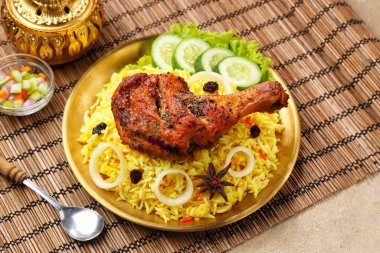 Kokulu Nasi Biryani geleneksel bir tabakta servis edilirken, aromatik baharatlar, taze tavuk, karamelize soğan ve taze otlarla pişirilmiş uzun taneli basmati pilavı servis edildi. Lezzetli Güney Asya ve Orta Doğu pirinç yemeği