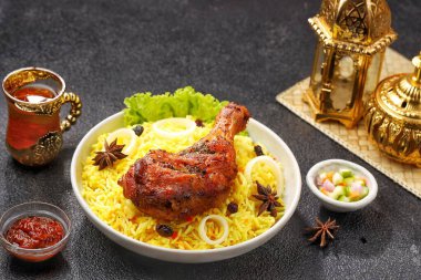 Kokulu Nasi Biryani geleneksel bir tabakta servis edilirken, aromatik baharatlar, taze tavuk, karamelize soğan ve taze otlarla pişirilmiş uzun taneli basmati pilavı servis edildi. Lezzetli Güney Asya ve Orta Doğu pirinç yemeği
