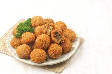 Yeşil maydanozlu garnitür ile servis edilen bir tabak altın kızartma.