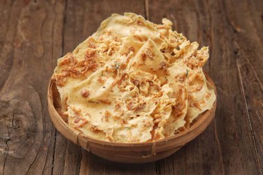 Tahta masaya kızarmış patates cipsi konmuş bir kase.