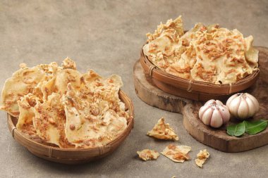 İki ahşap kase dokulu yüzeyde gevrek kızartma cipsiyle dolu.