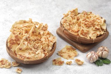 Beyaz yüzeye serpiştirilmiş kremalı sarımsakla dolu iki tahta kase.