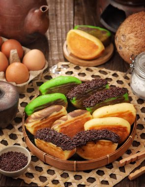 Çikolata, portakal ve yeşil hamur işleriyle dolu renkli tabaklar.