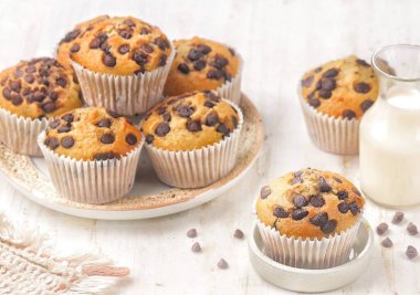 Beyaz ahşap yüzeyde sütle düzenlenmiş çikolatalı kek tabağı.