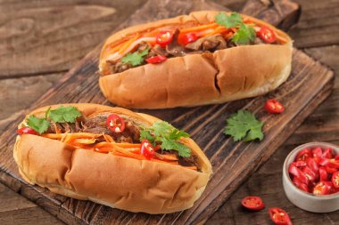 Tahtada et, sebze ve otlarla dolu iki taze sandviç.