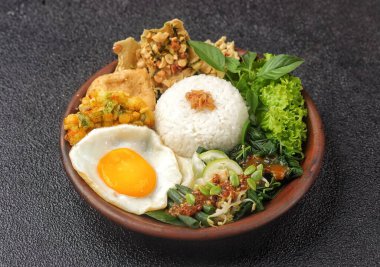 Nasi Campur Bali, dilimlenmiş tavuk, sate lilit, lawar ve sambal matah gibi küçük porsiyonlarda sıcak beyaz pirinç ve çeşitli mezelerden oluşan geleneksel bir Bali yemeğidir.