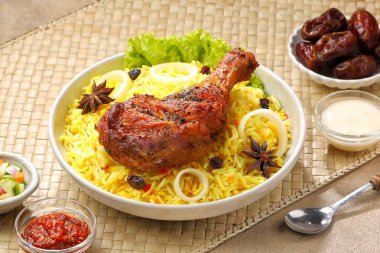 Kokulu Nasi Biryani geleneksel bir tabakta servis edilerek aromatik baharatlar, taze tavuk, karamelize soğan ve taze otlarla pişirilmiş uzun taneli basmati pilavı sunuldu..