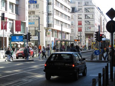 Berlin 'deki Friedrichstrae' de canlı şehir kavşağında toplu taşıma altyapısı, yayalar ve araçlar bulunuyor. Almanya 'nın başkentinde otantik kentsel atmosfer. (04 / 03 / 2025 Berlin Almanya)