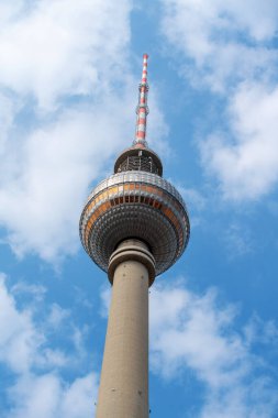 Berlin, Almanya 'da Alexanderplatz' da bulunan TV Kulesi, bulutlu mavi gökyüzünün arka planında yer almaktadır.