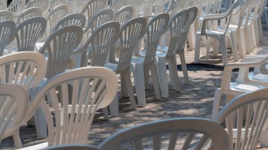 Şehir meydanında halk bayramı için hazırlanmış bir sürü plastik sandalye var..