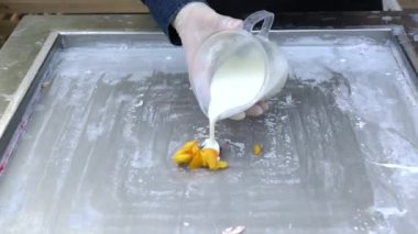 Doğal meyveli Tayland dondurması. Soğuk tabakta rulo dondurmanın üretimi. Şefler kızartma tavasında dondurma yapıyor, el yapımı dondurma tatlısı.. 