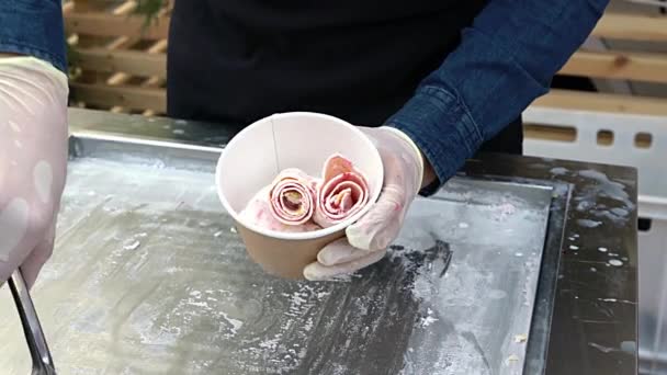 Wykonanie naturalnych owoców tajskie lody. Produkcja lodów w rolkach na zimnym talerzu. Kucharze robią roladki lodów na patelni, ręcznie robiony deser lodowy. — Wideo stockowe