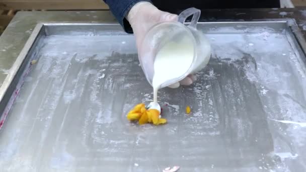 Fabrication de fruits naturels crème glacée thaïlandaise. Production de crème glacée en rouleaux sur une plaque froide. Les chefs font des rouleaux de crème glacée sur une poêle à frire, dessert à la crème glacée fait main. — Video